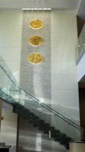 Beautiful glass staircase with cascade wall with art installation